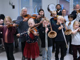 Børn og voksne står med deres instrumenter i hånden